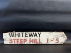 A double sided wooden directional sign pointing towards Whiteway, also warning of a steep hill 1-