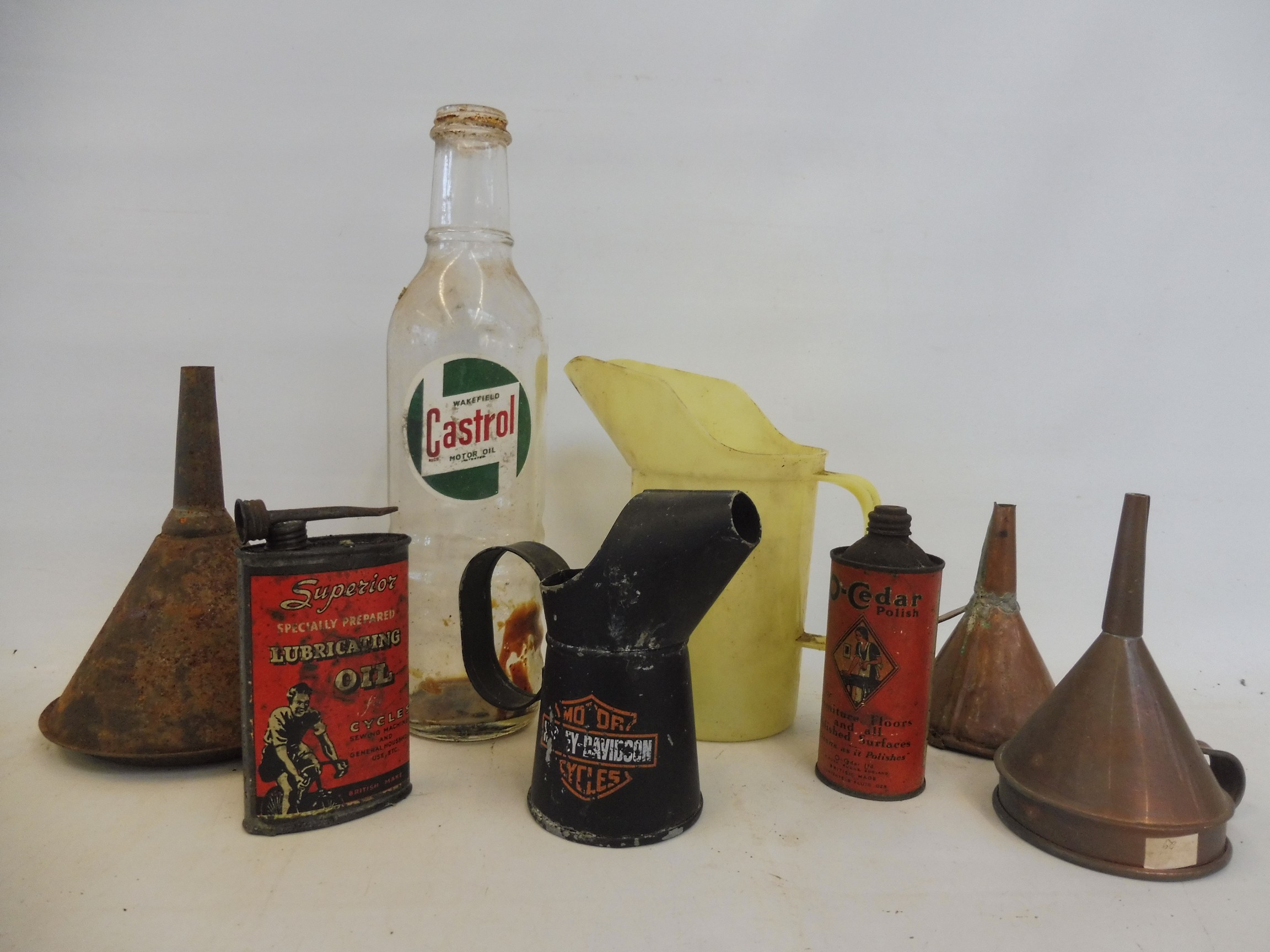 A Wakefield Castrol quart glass bottle and various oil cans, funnels and measures.