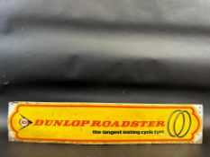 A rectangular tin sign advertising Dunlop Roadster cycle tyres, 27 3/4 x 5 3/4".