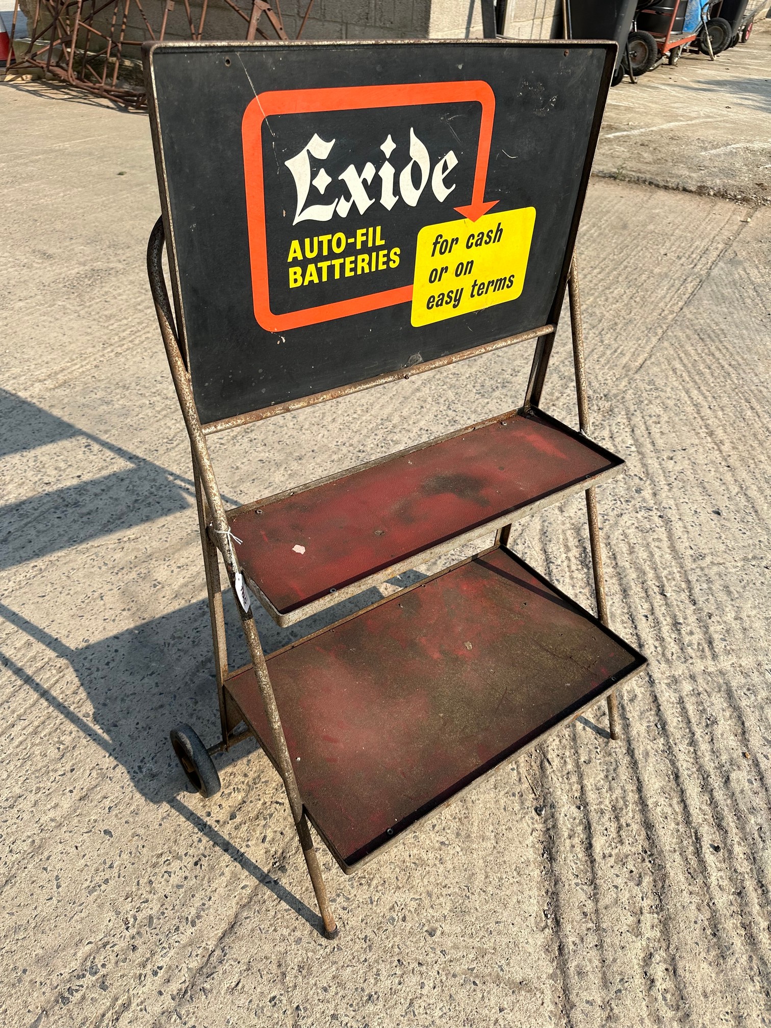 A garage forecourt two tier trolley with pediment sign advertising Exide Auto-Fil Batteries.