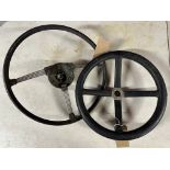 A vintage four spoke steering wheel and one other.