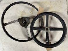 A vintage four spoke steering wheel and one other.