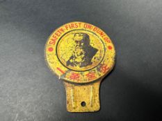 An unusual Dunlop tin 'safety first' badge with Oriental characters below an image of 'Mr Dunlop'.