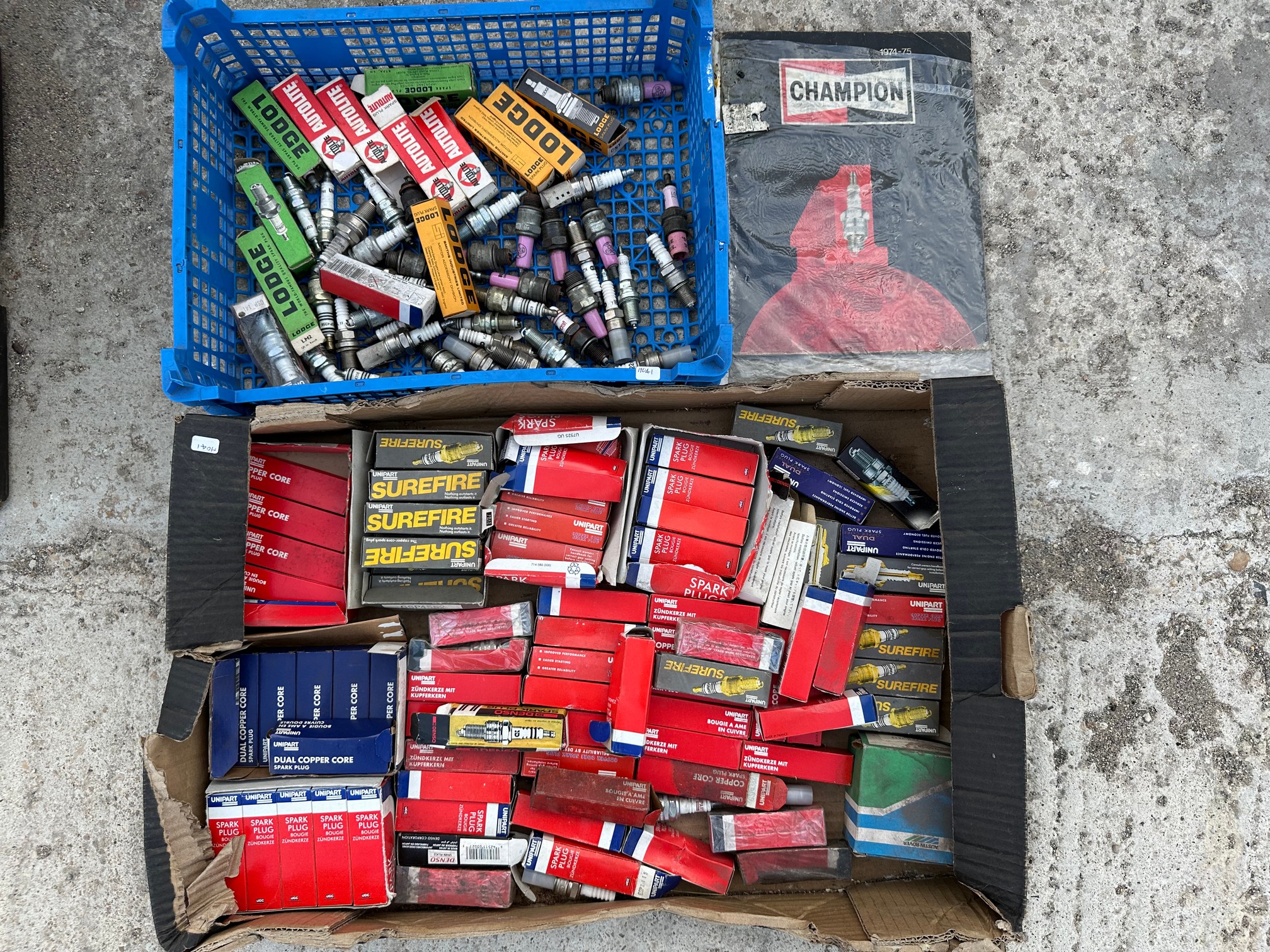 Two trays of spark plugs, some boxed.