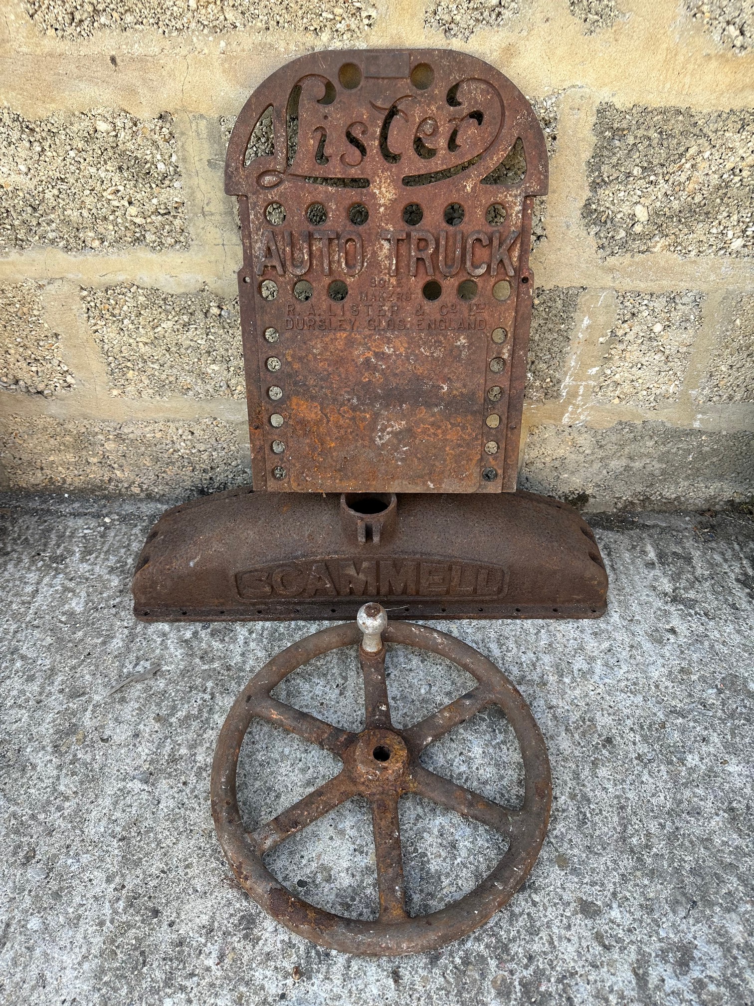 A cast iron Lister Auto Truck plate, a Scammel radiator header tank and a steam engine wheel.