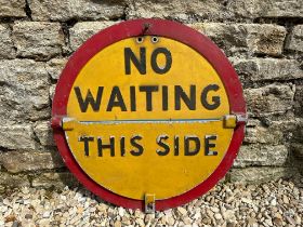 A circular 'No Waiting' aluminium road sign with semi-circular hinged section revealing different