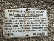 A London North Eastern Railway LNER 'warning to trespasser's heavy cast iron road sign, with crack