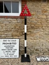 A roadside post topped by cast alloy warning triangle with reflectors 18" x 89"