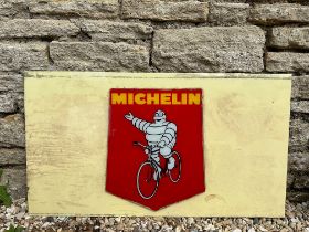 A Michelin pictorial glass advertising sign attached to a milk glass panel, 34 1/2 x 19".