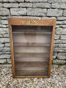 A Desmo wooden front-opening display cabinet with celluloid badge inside of door, 23 3/4 x 36".