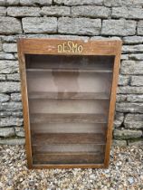 A Desmo wooden front-opening display cabinet with celluloid badge inside of door, 23 3/4 x 36".