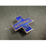 A Price's Motorine cross shaped enamel lapel badge, stamped Butler to verso.