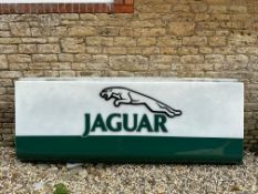 A large Jaguar dealership acrylic advertising sign panel with raised logo and lettering, damage to