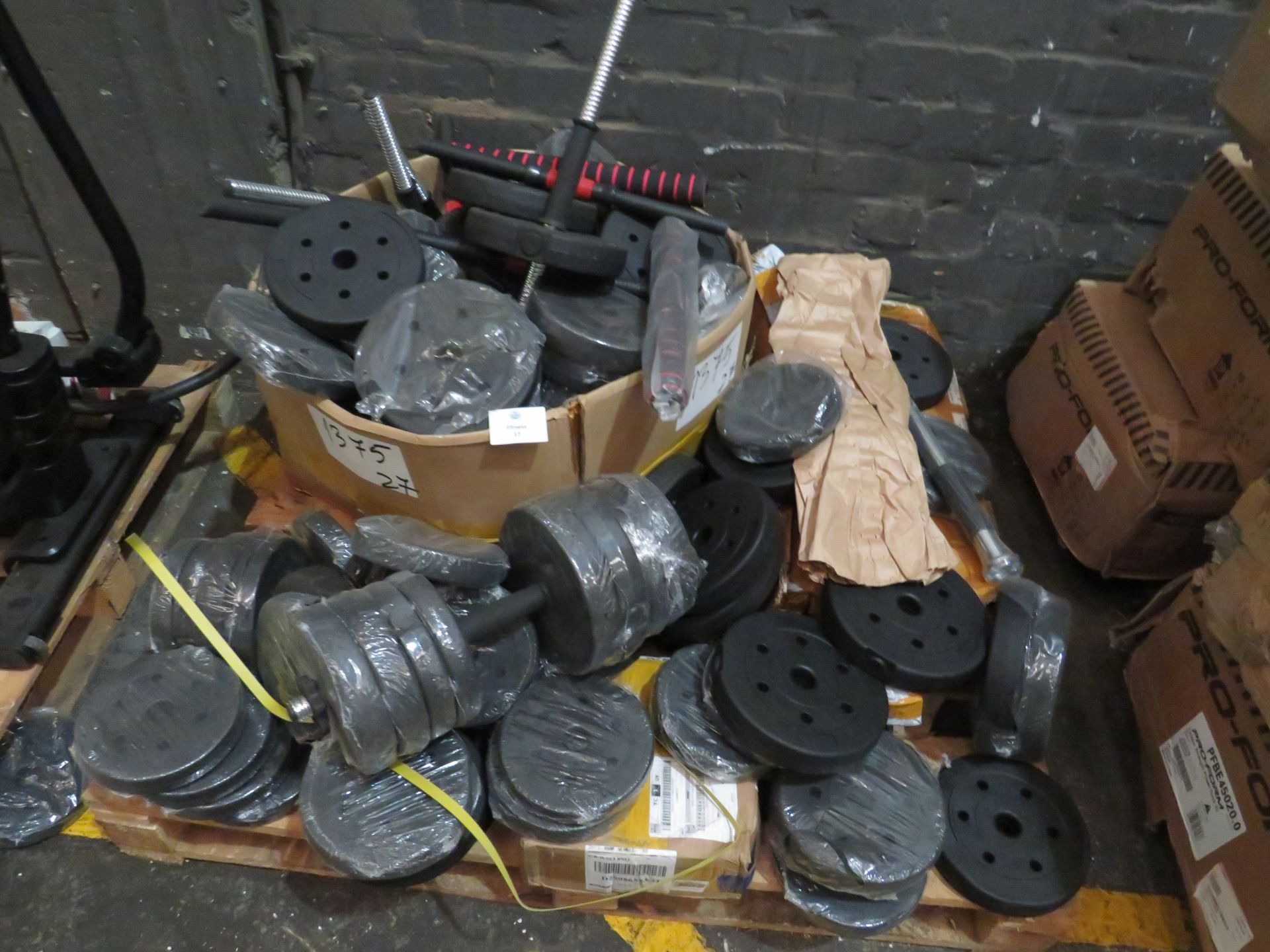 Pallet of mixed fitness items which includes loose dumbells, loose circular weights and chin up