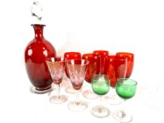A cranberry glass decanter, five cranberry glass wine glasses and other glasses
