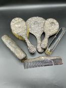 Two silver backed dressing table hand mirrors; together with three brushes
