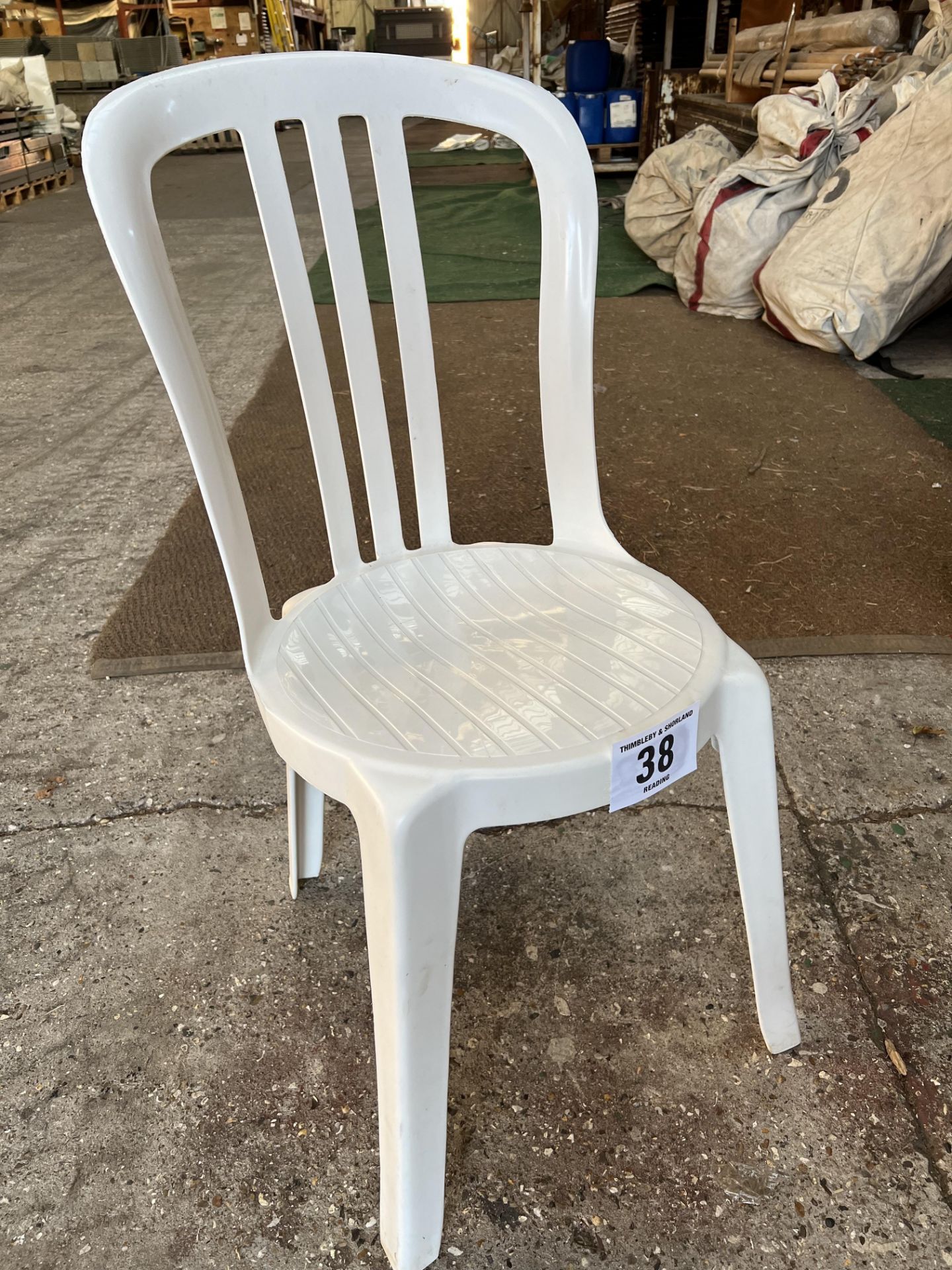 50 white resin bistro chairs. This lot is subject to VAT