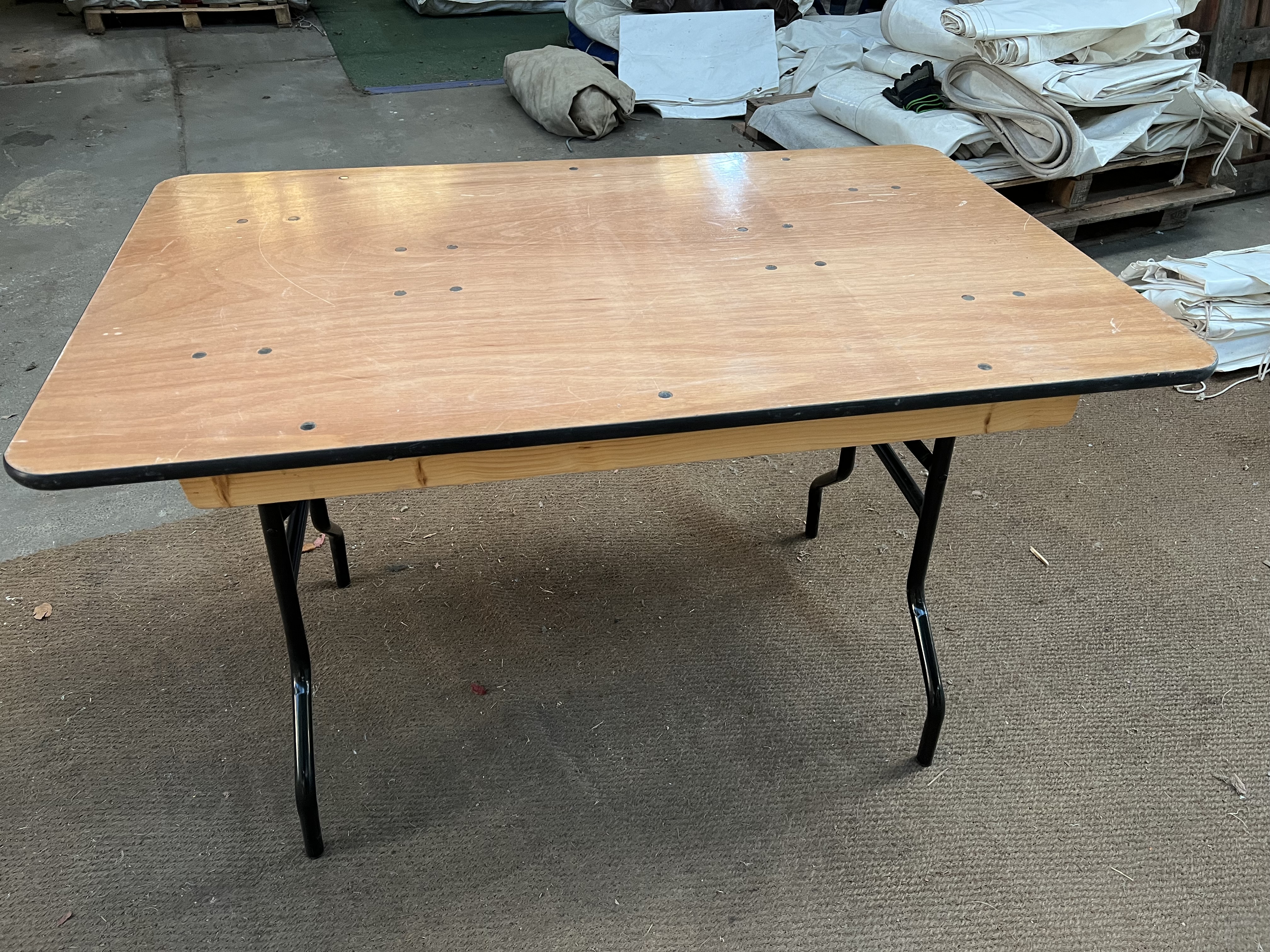 25 no 4ft x 2ft 6in trestle tables with folding legs and plywood top. This lot is subject to VAT.