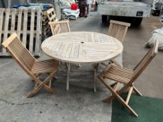 4ft diameter teak circular table with 4 folding teak chairs. This lot is subject to VAT