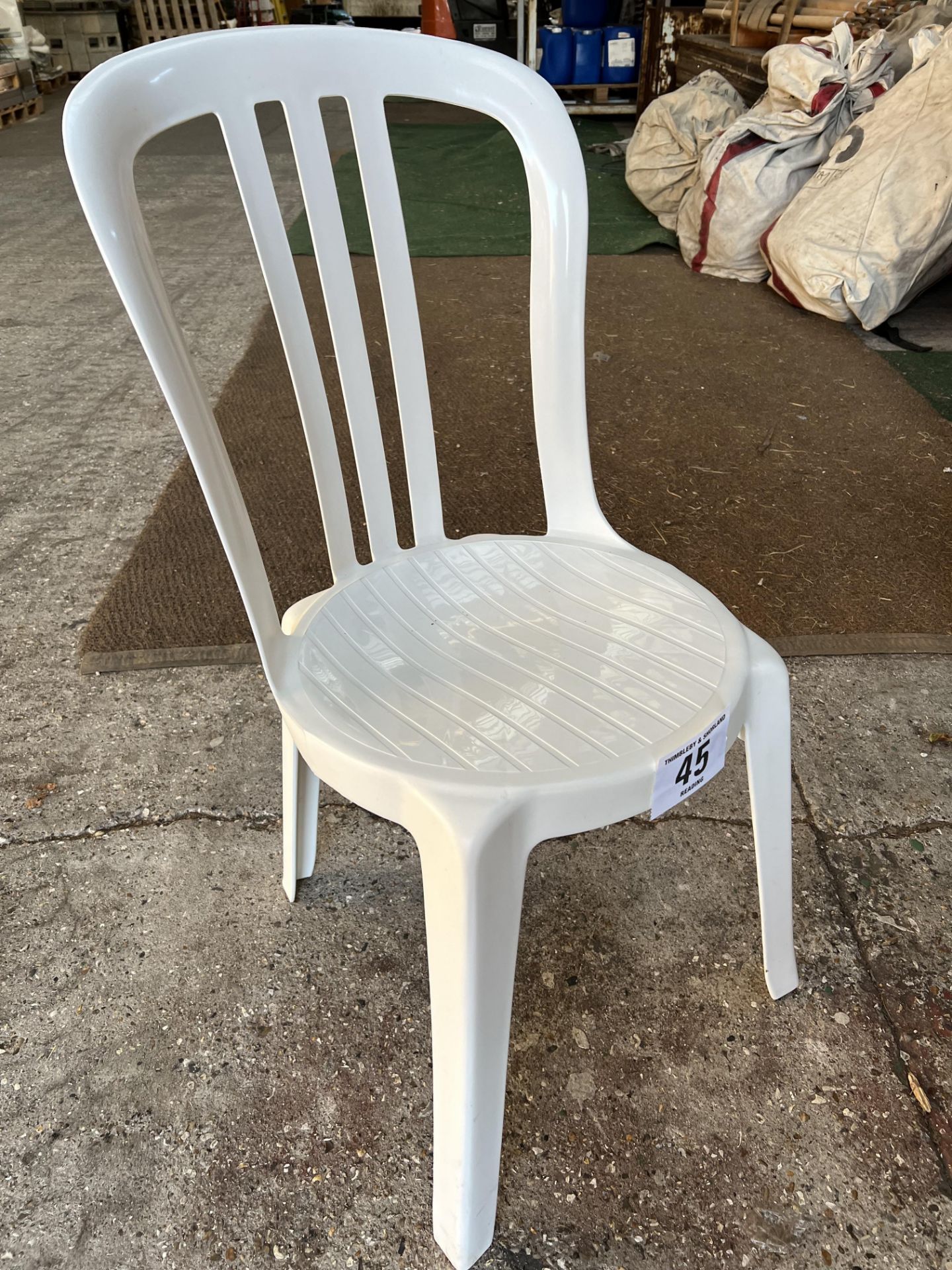 50 white resin bistro chairs. This lot is subject to VAT