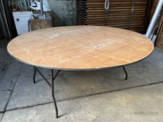 12 no 6ft diameter round tables with folding legs and plywood top. This lot is subject to VAT.