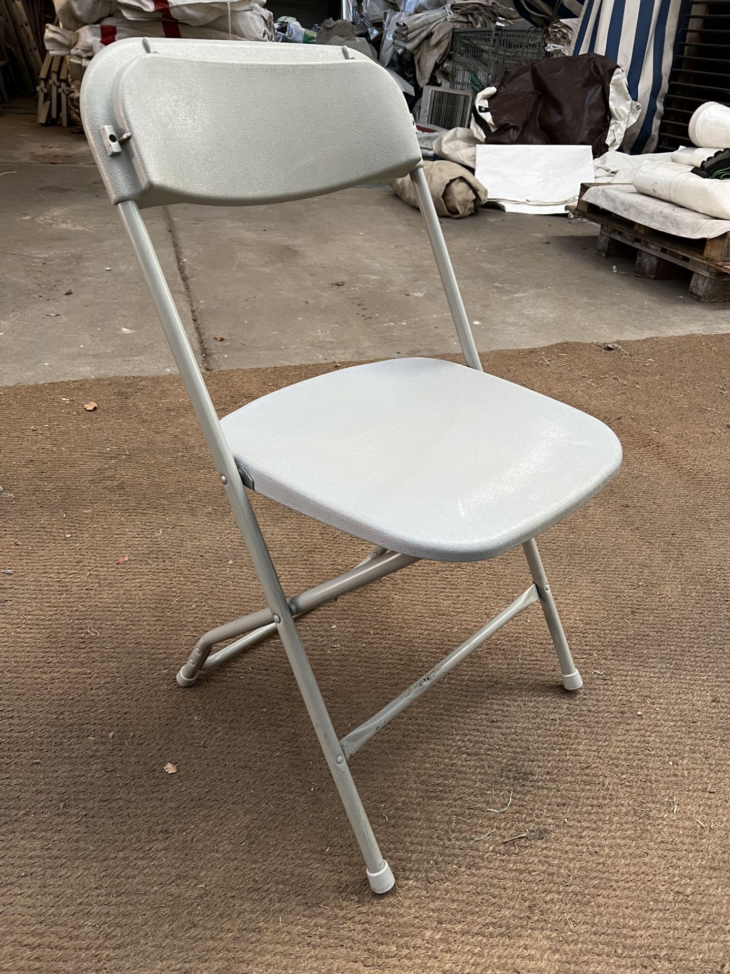 100 Samsonite folding chairs, light grey. This lot is subject to VAT.
