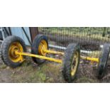 Pair of yellow dray axles with wheels