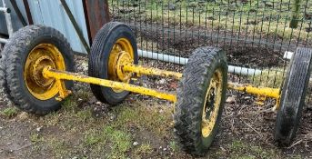 Pair of yellow dray axles with wheels