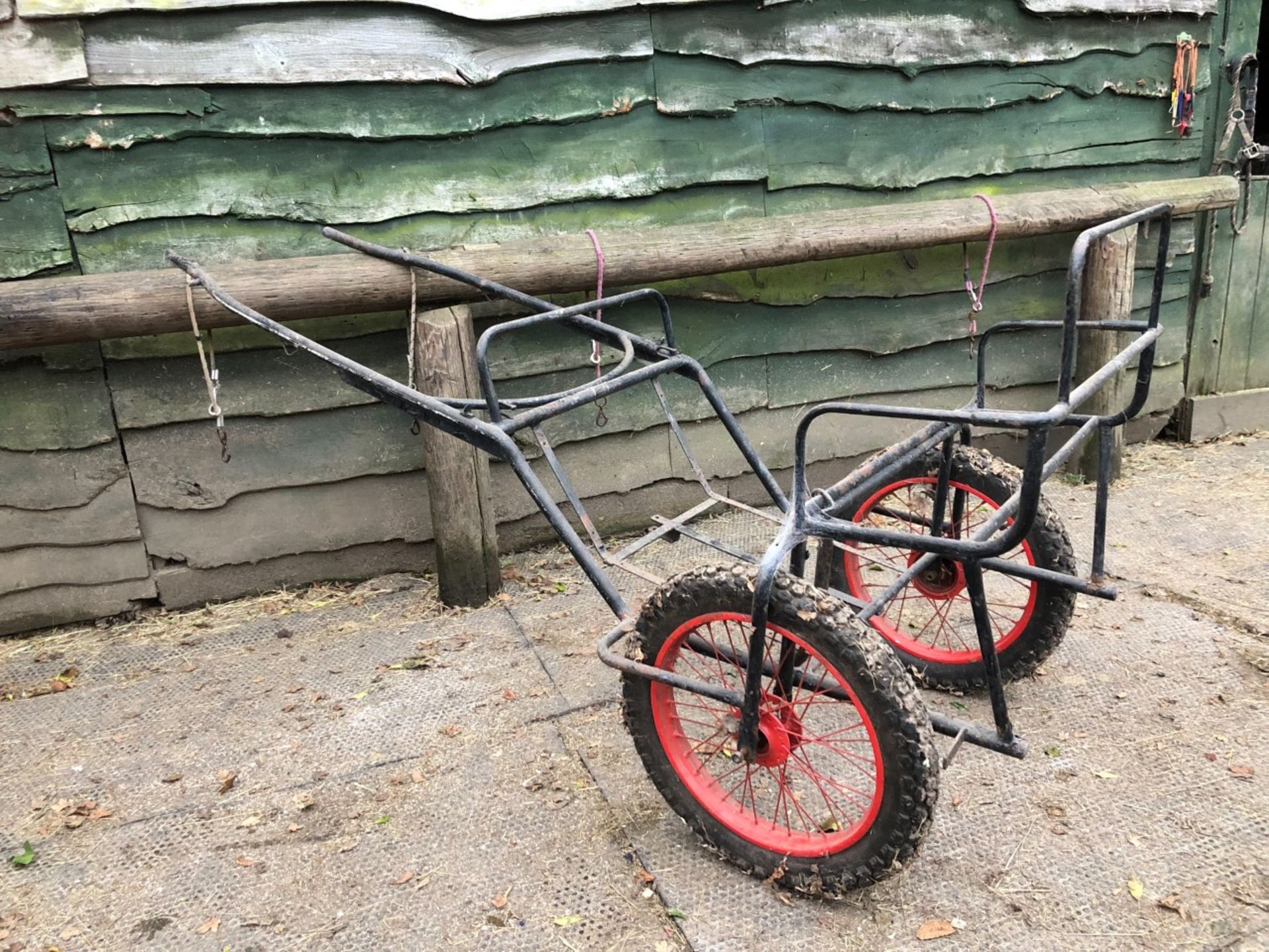 EXERCISE CARRIAGE FRAME painted black with new red wire wheels on pneumatic tyres.