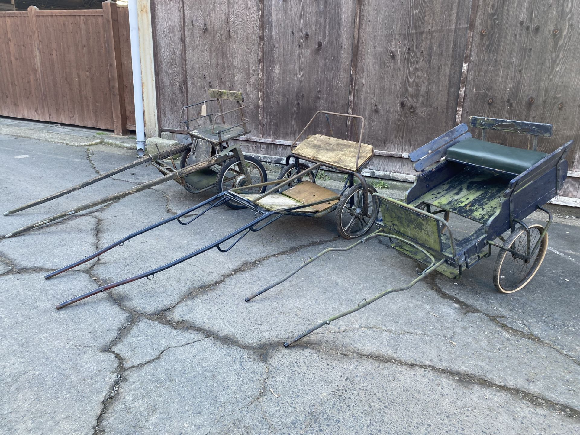 FOUR EXERCISE CARTS comprising three 2 wheel carts with metal frames and wire wheels; together