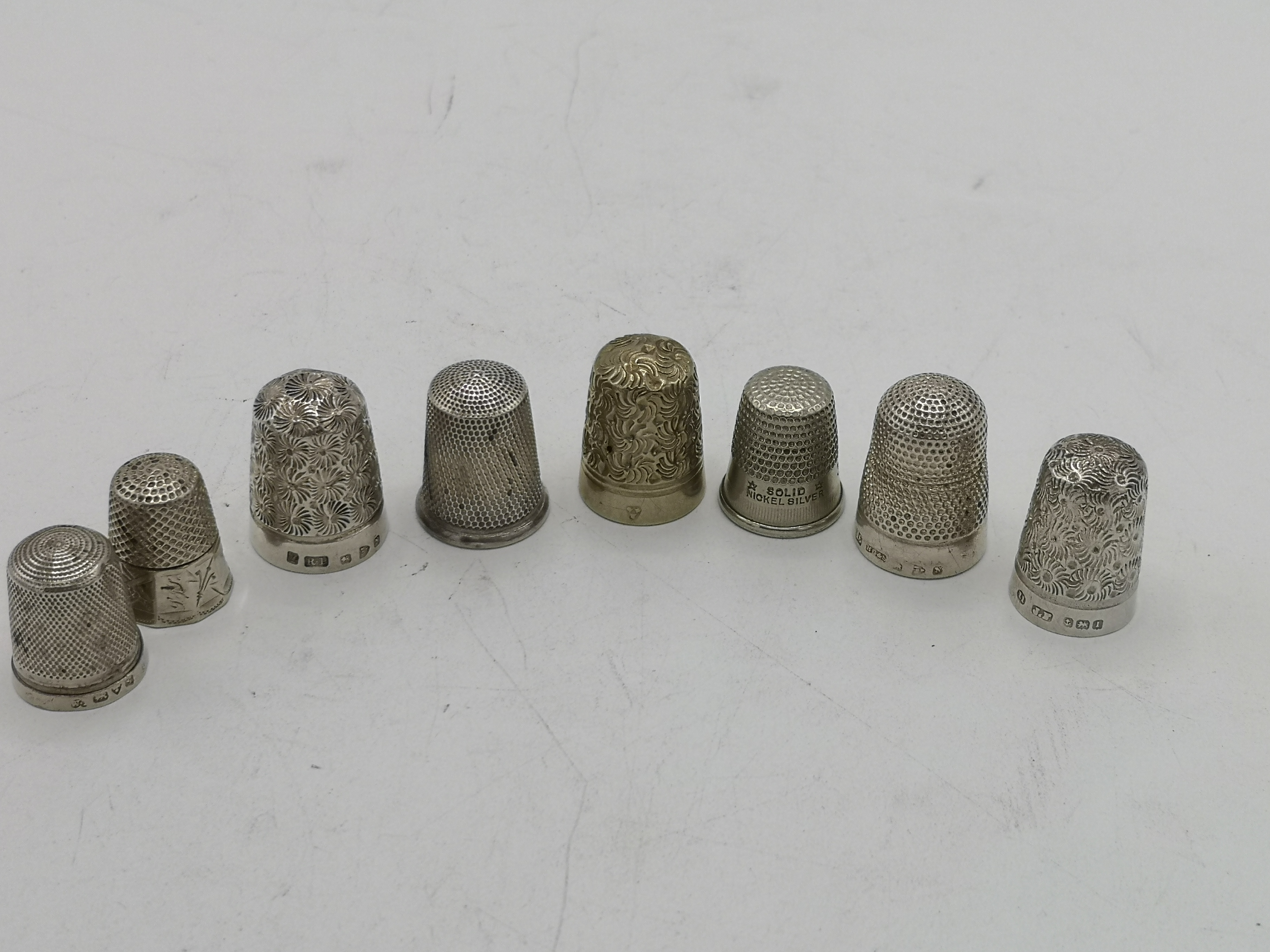 Five silver thimbles together with three others