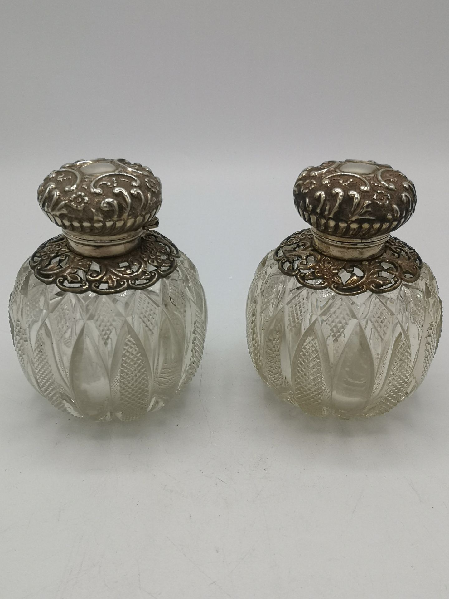 Two cut glass and silver perfume bottles