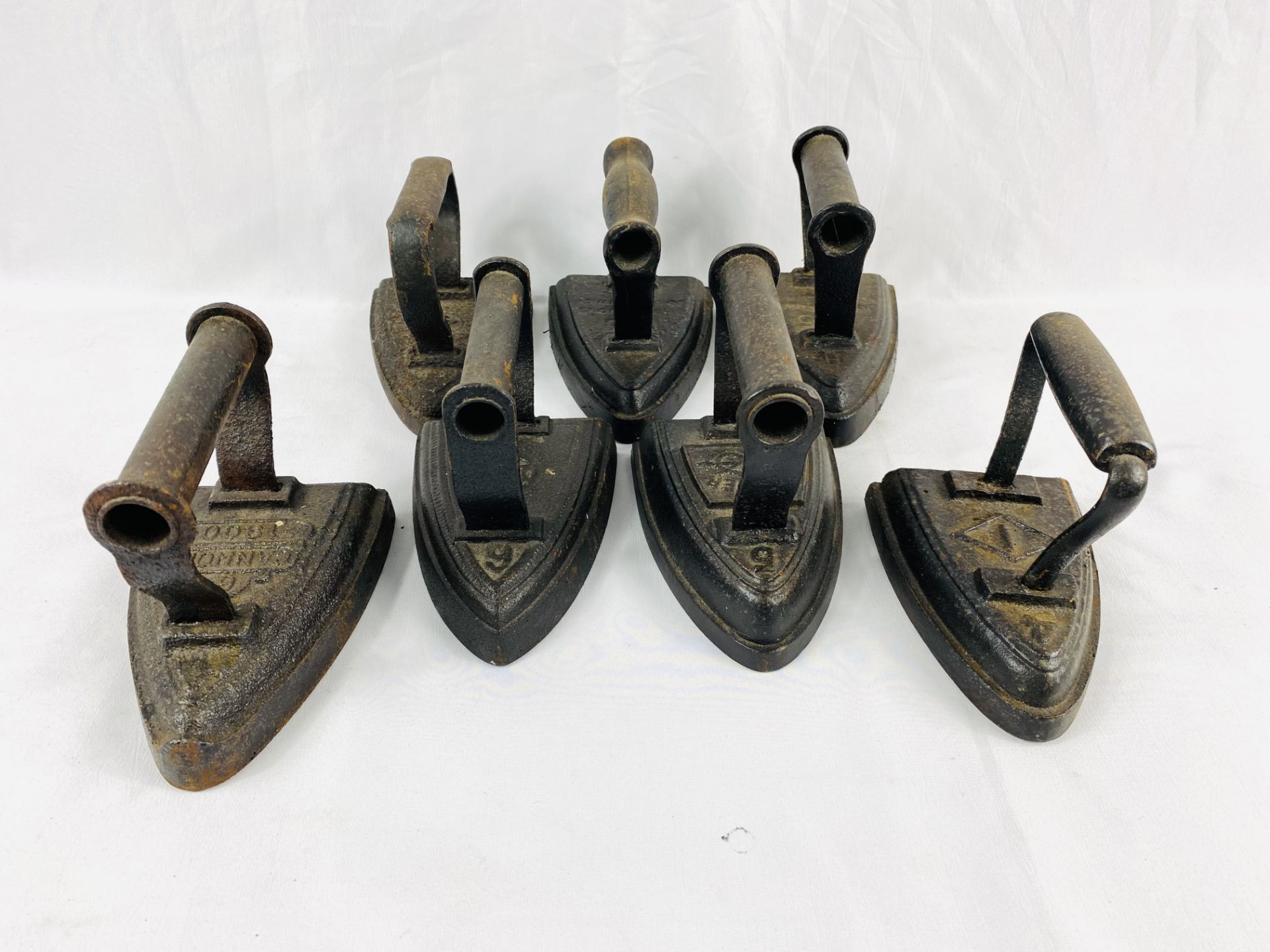 Seven cast iron flat irons