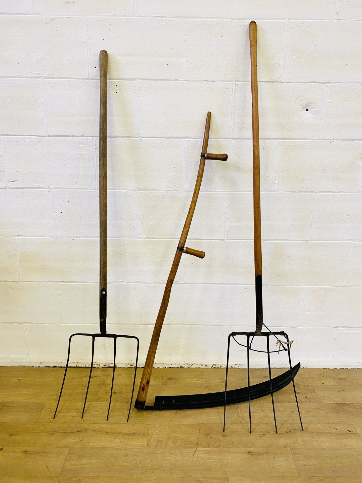 A scythe and two pitchforks