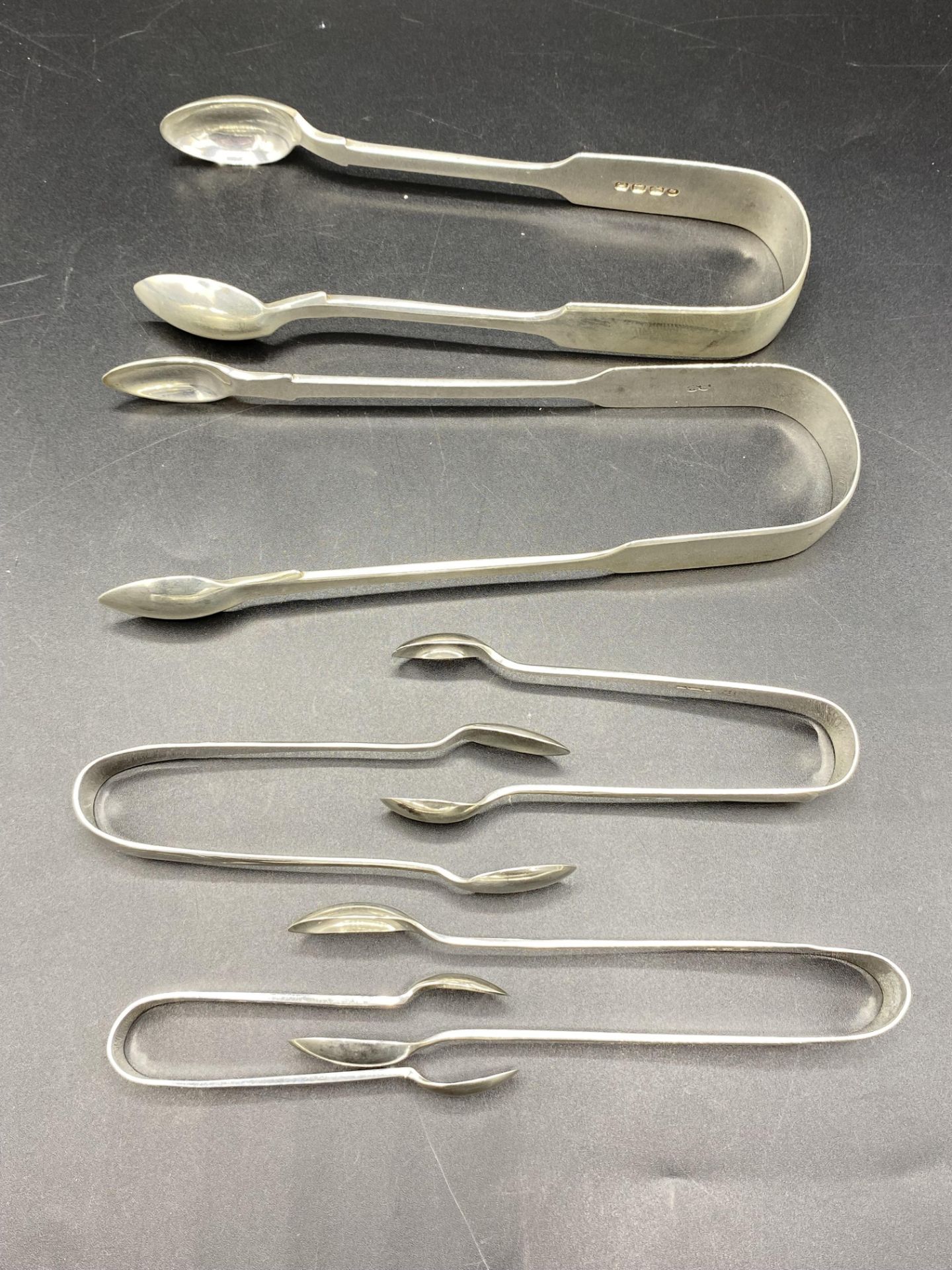 Six pair of silver sugar tongs