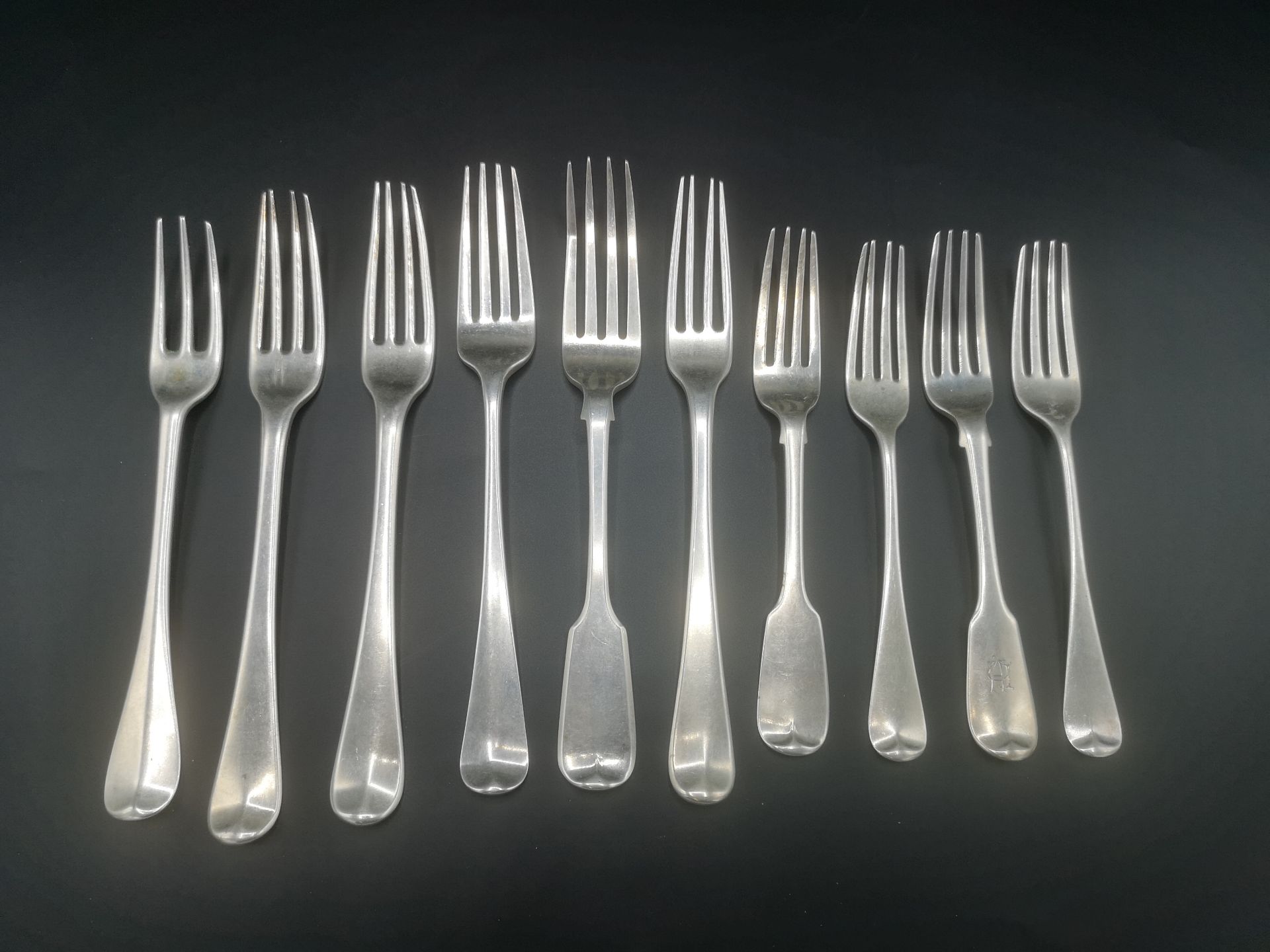 Three Georgian silver forks, together with seven other silver forks
