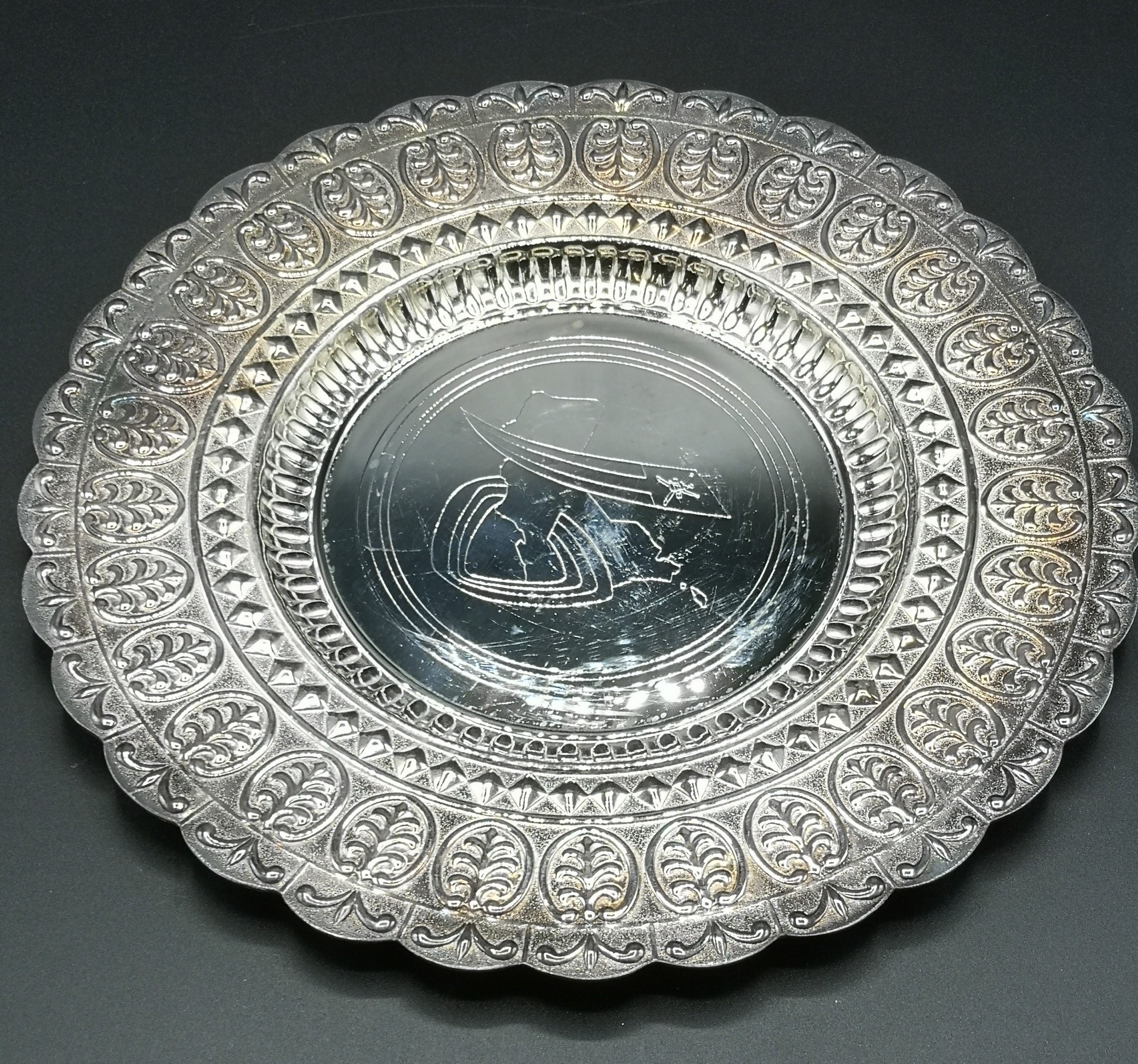 Silver dish with Omani logo to centre