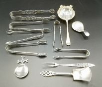 Silver tea strainer with other silver spoons together with silver plate sugar tongs
