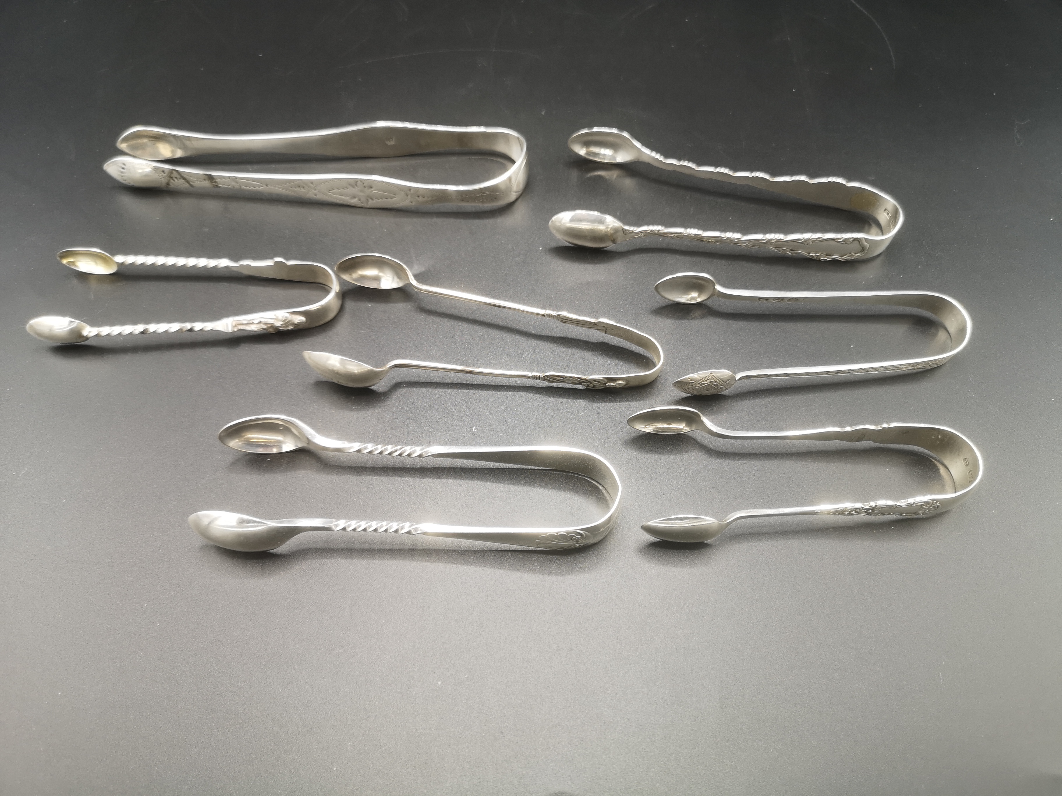 Seven pairs of silver sugar tongs