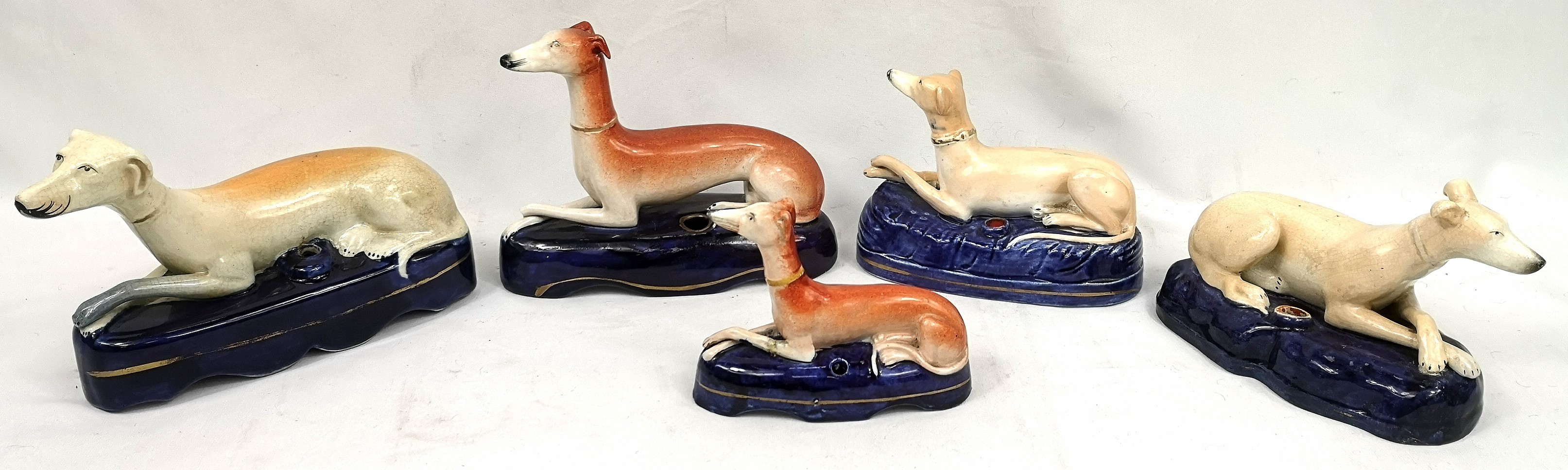 Five Staffordshire dog quill holders
