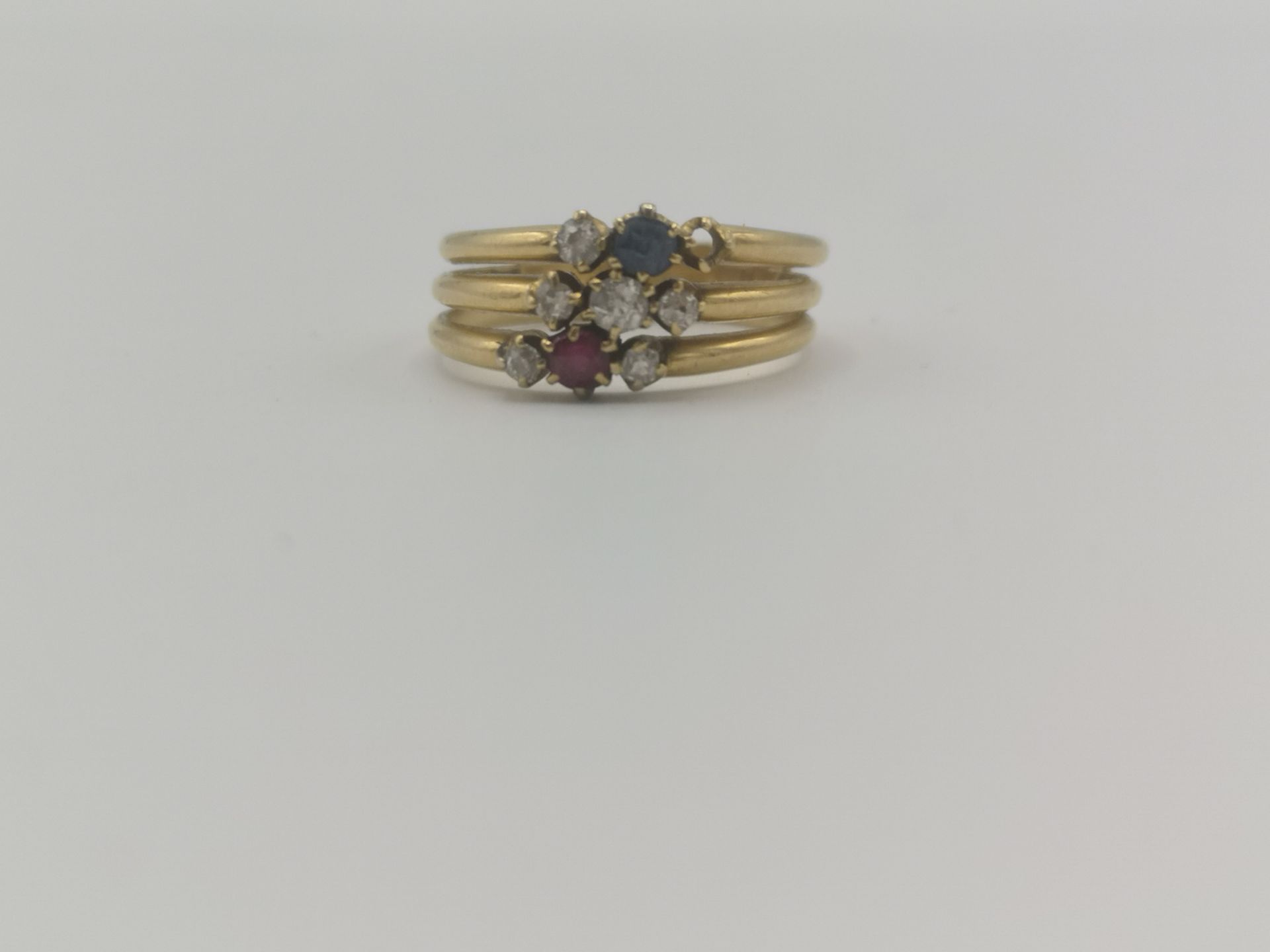 18ct gold triple ring set with six diamonds, a ruby and a sapphire - Image 2 of 4
