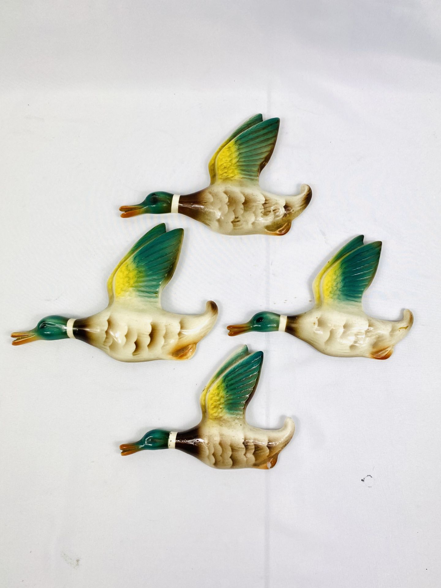 Four graduated ceramic flying ducks