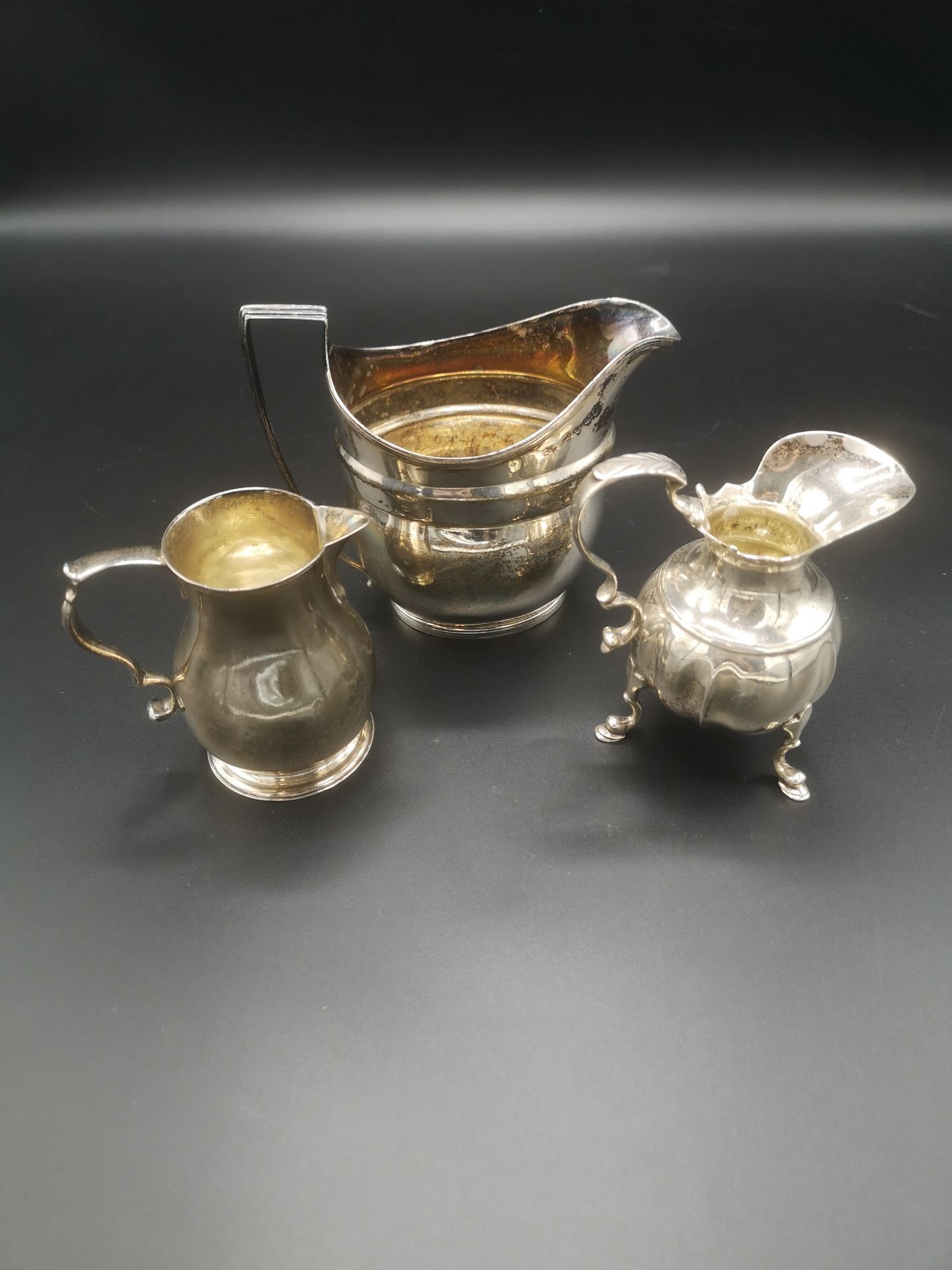 Two Georgian silver jugs together with a Victorian silver jug