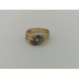 18ct gold triple ring set with six diamonds, a ruby and a sapphire