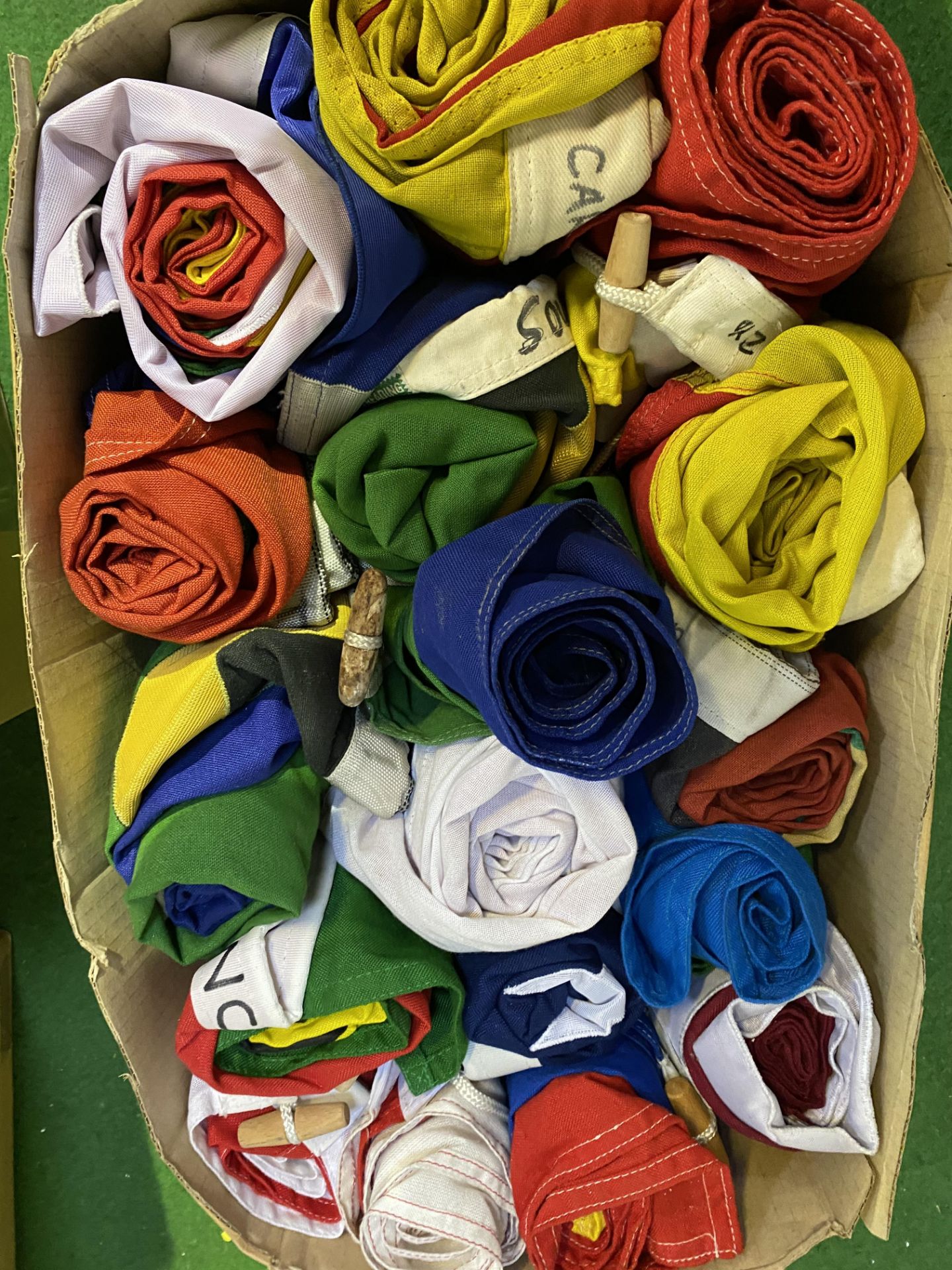 A box of seventeen flags from ten countries. This lot is subject to VAT.