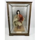 Japanese doll in traditional costume in glass case