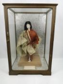 Japanese doll in traditional costume in glass case