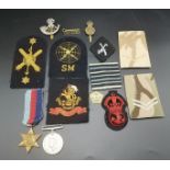 Two WWII medals together with a quantity of military patches and badges