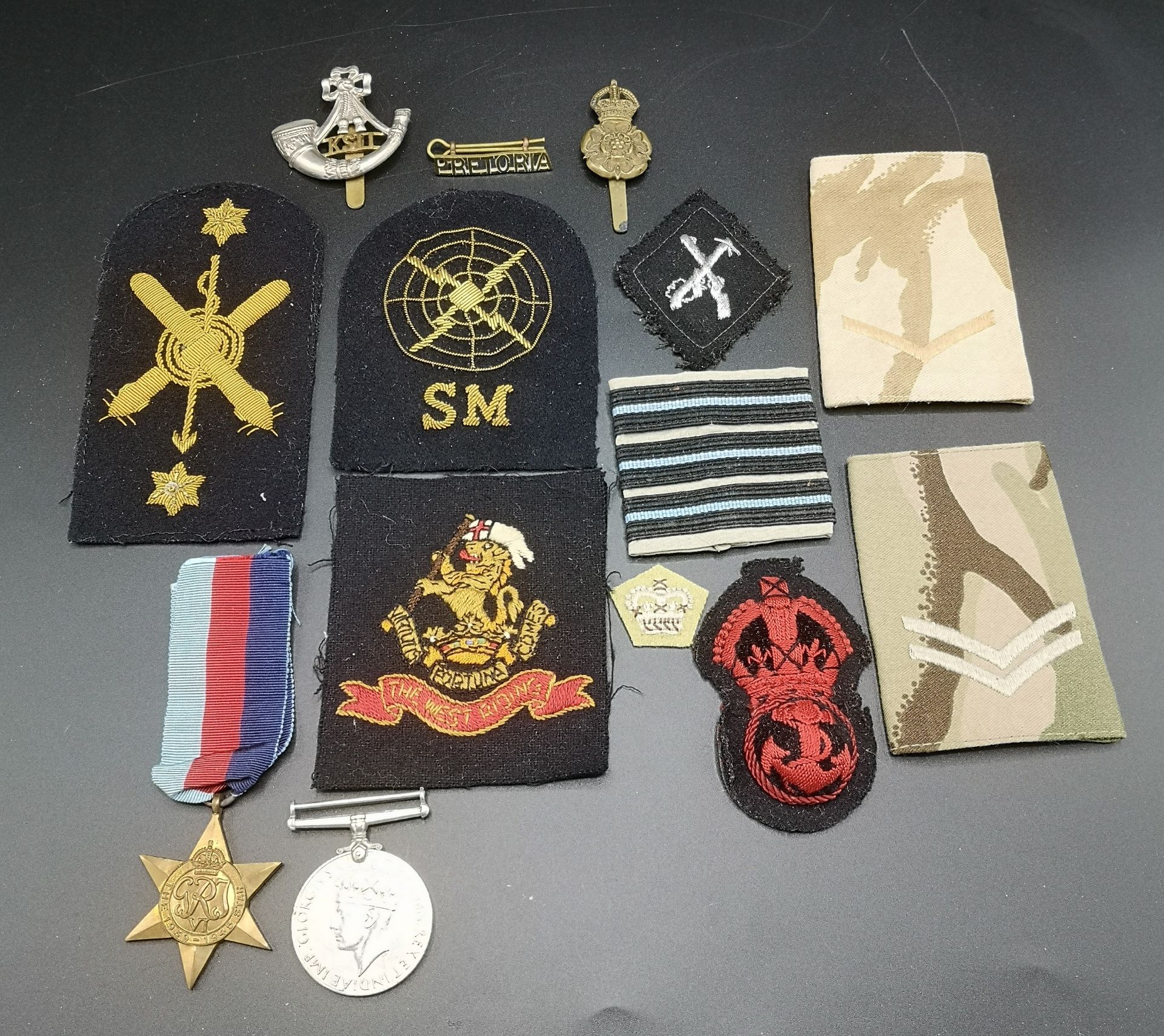 Two WWII medals together with a quantity of military patches and badges
