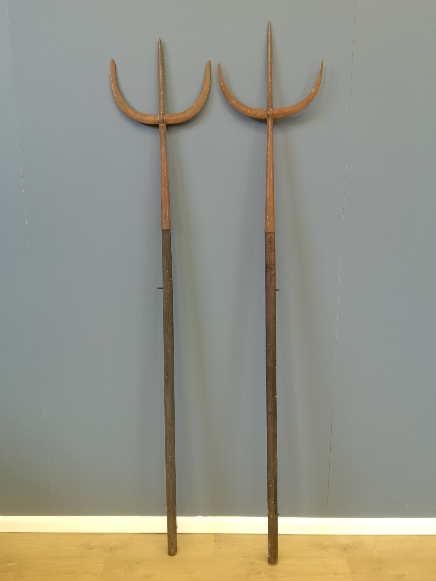 Two wood tridents with metal forks